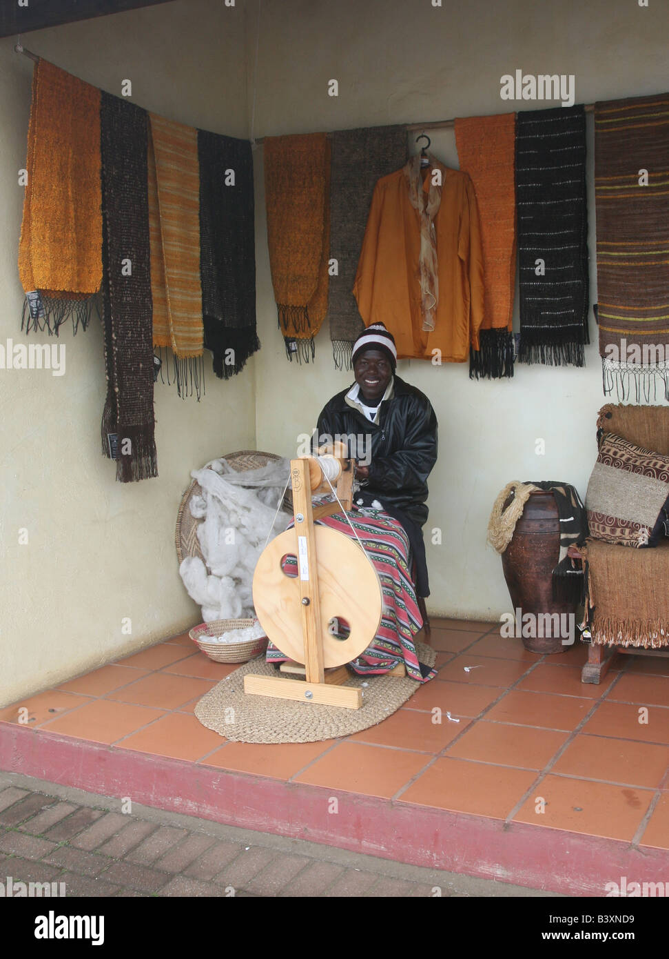 Une femme africaine à Graskop Mpumalanga Afrique du Sud sur une filature de soie filature roues pour être transformé en tapisserie murale Banque D'Images