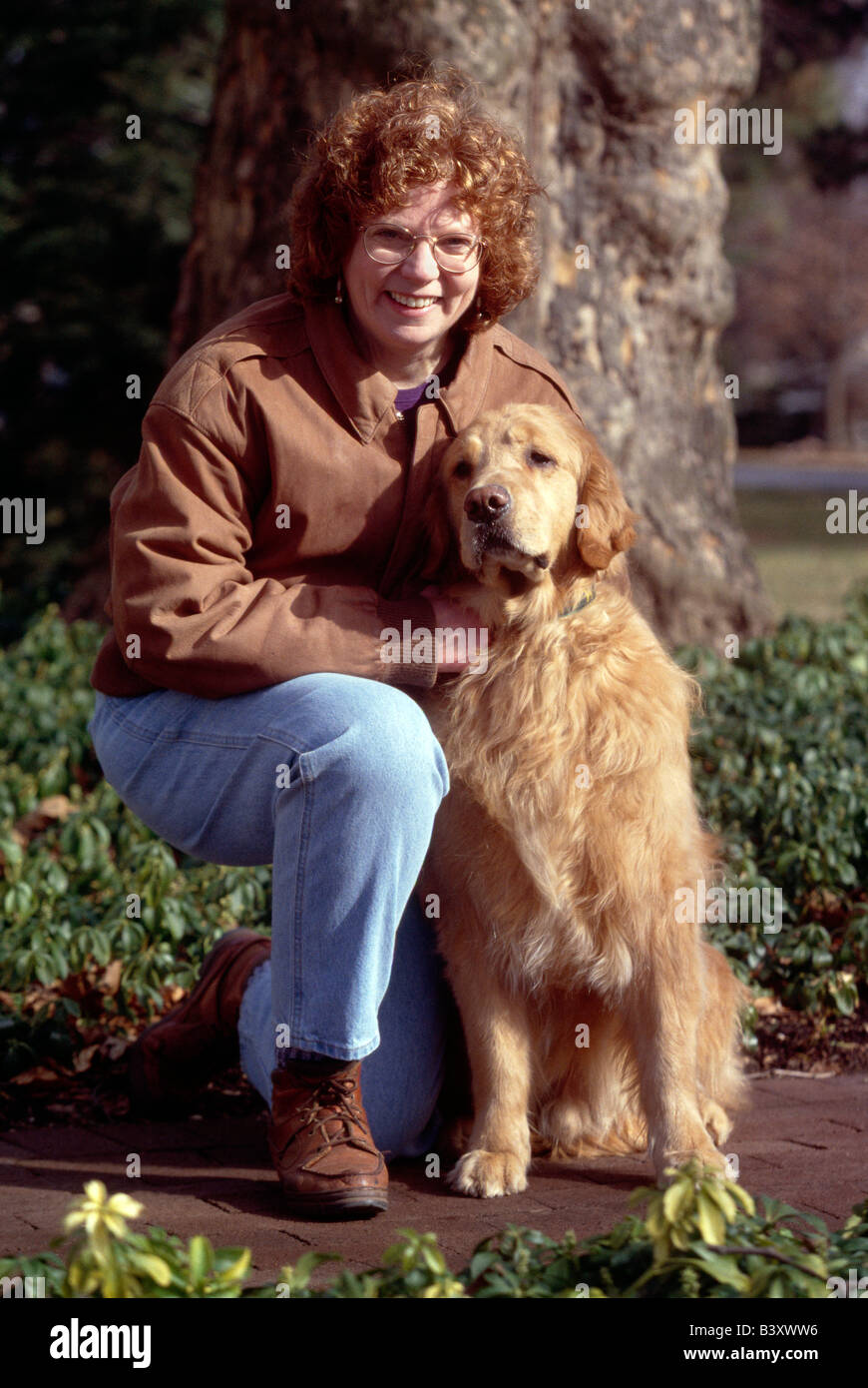 Portrait de femme d'âge moyen et son chien Golden Retriever. La femme prend le chien pour visiter les enfants comme une forme de thérapie Banque D'Images