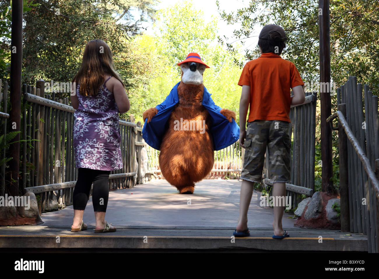 Un personnage de Disney marche autour de Disneyland, avec des enfants au premier plan. Banque D'Images