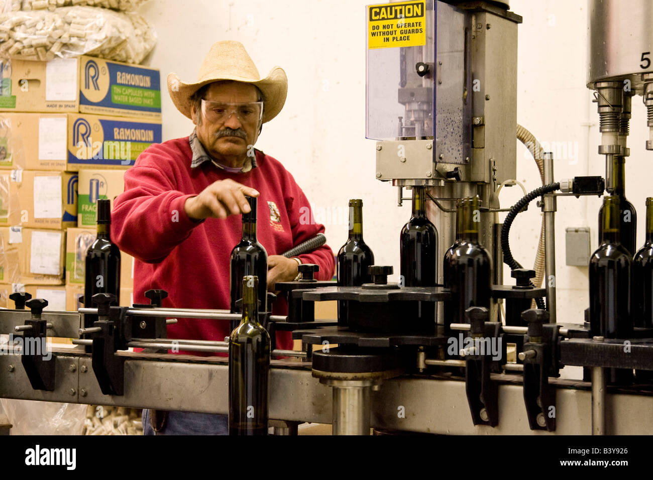 États-unis, Californie, Napa Valley. L'homme travaillant sur ligne d'assemblage que les bouteilles de vin. Banque D'Images