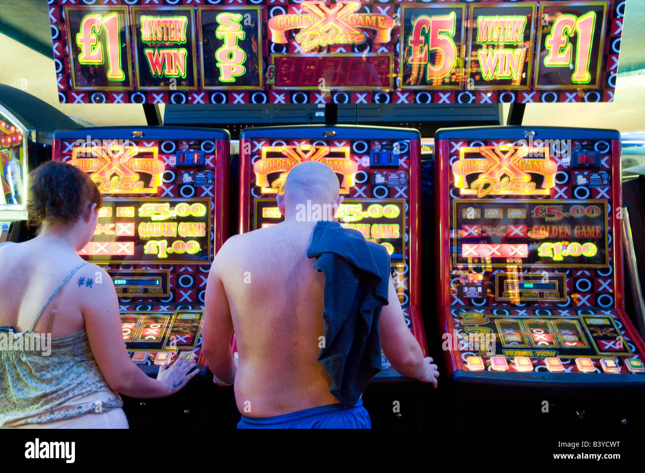 Personnes jouant sur les fruits dans les machines de jeux électroniques, UK Banque D'Images