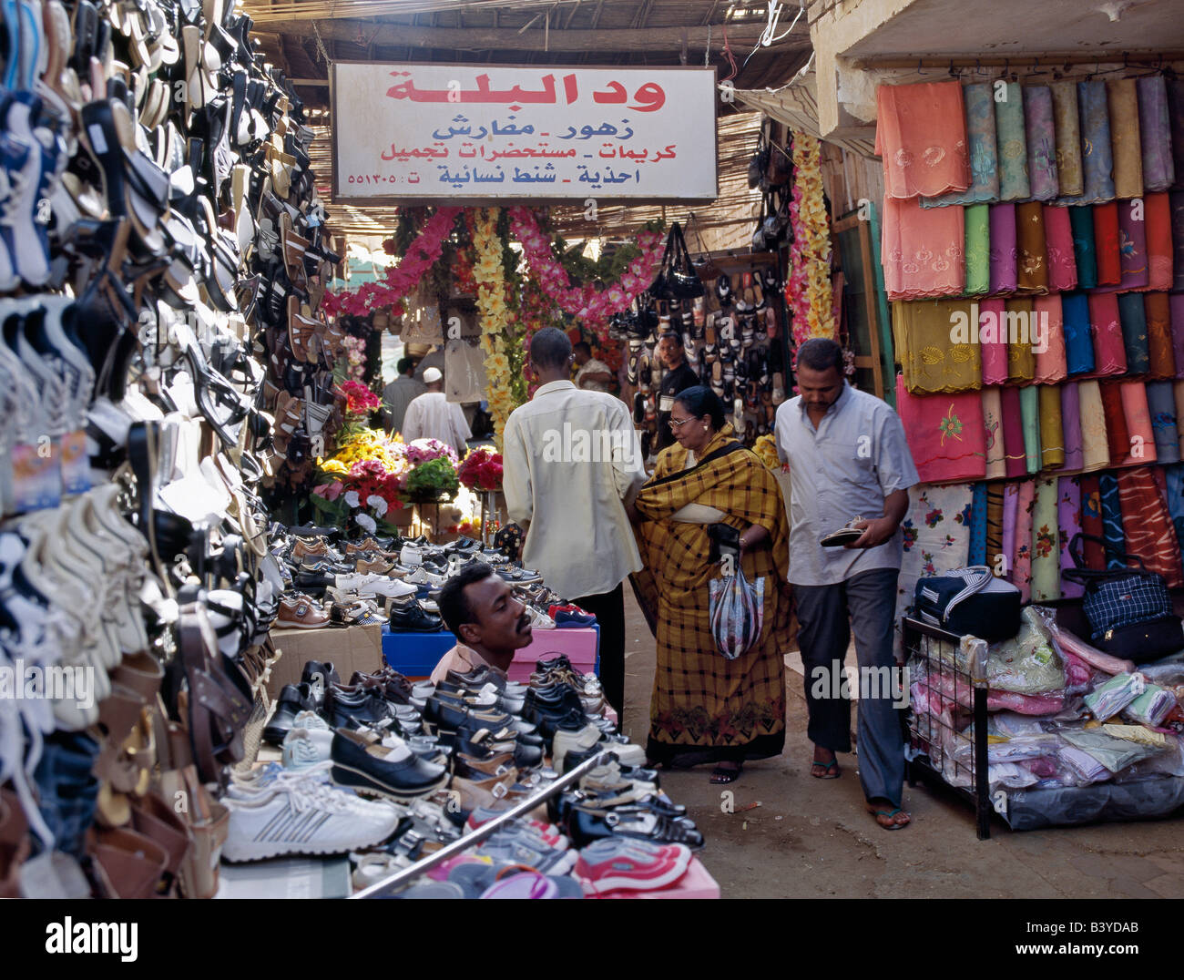 Soudan, Khartoum, Omdurman. Vêtements et chaussures sont affichées dans les petites boutiques à la façade ouverte une ruelle étroite dans l'un des centres du marché très animé d'Omdurman. Banque D'Images