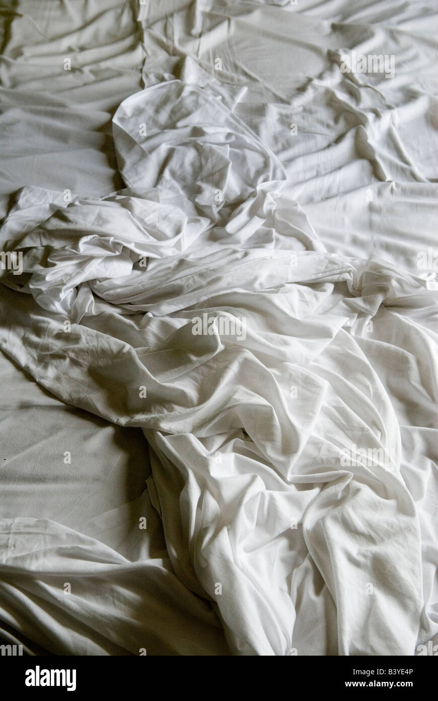 Draps froissés froissés un lit non fait draps blancs dormaient. HOMER SYKES Banque D'Images