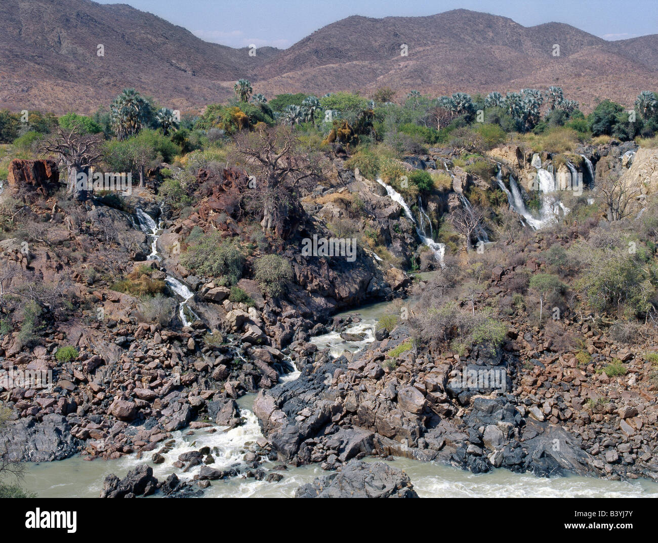 La Namibie, Kaokoland, Epupa. Epupa Falls dans le nord-ouest de la Namibie sauvage sont une série de voies parallèles où la rivière Kunene tombe à 60 mètres dans un kilomètre et demi. Dans cette région éloignée, la rivière forme la frontière entre l'Angola et la Namibie. Epupa '' dans la langue Herero local signifie "eaux chute'. Banque D'Images