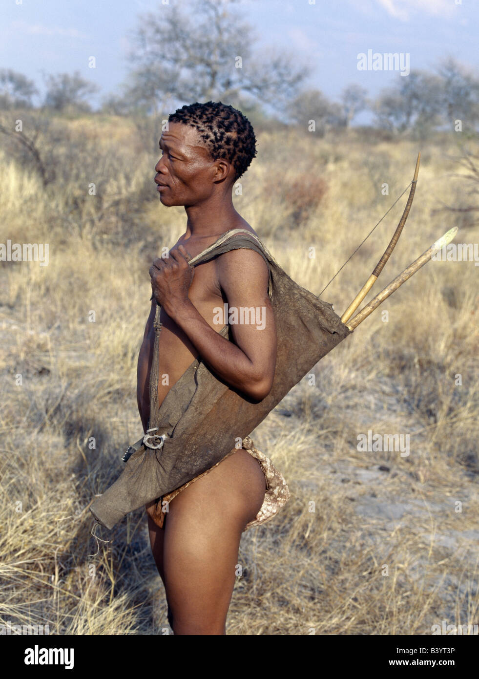 La Namibie, l'Est Bushmanland, Tsumkwe. Un chasseur-cueilleur !Kung est prête à accompagner ses amis à la chasse. Son arc et arr Banque D'Images