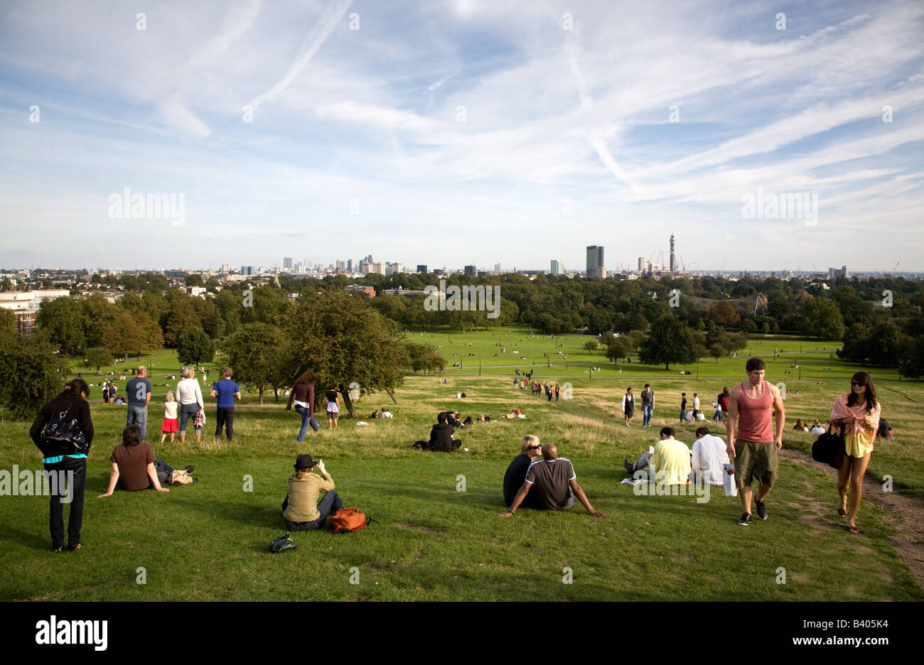 Les gens se détendre sur un dimanche après-midi ensoleillé sur Primrose Hill un parc public de Londres Banque D'Images