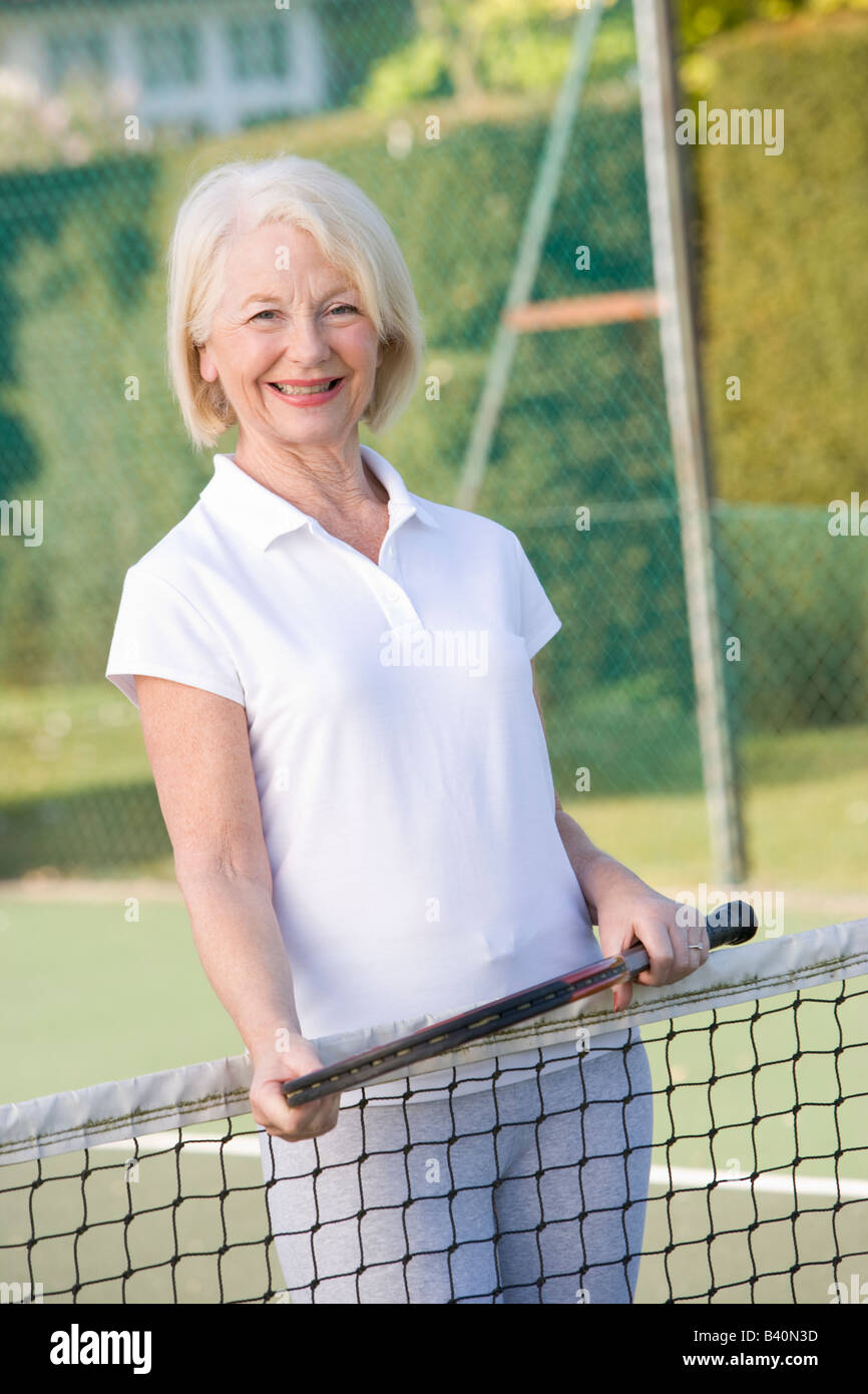 Femme jouant au tennis et souriant Banque D'Images