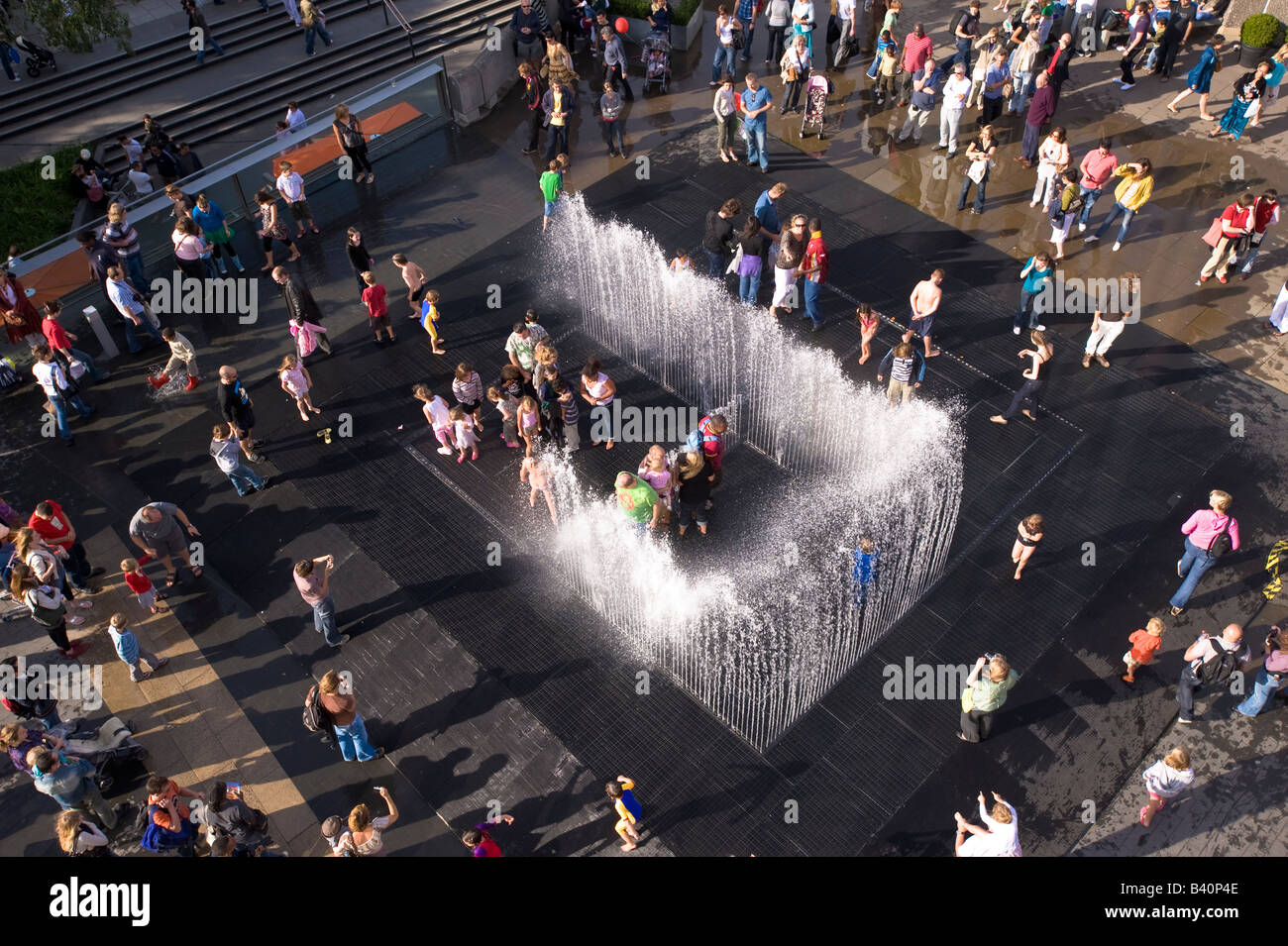 Les familles et les enfants jouer sur chaude journée d'été à fountain Southbank London United Kingdom Banque D'Images