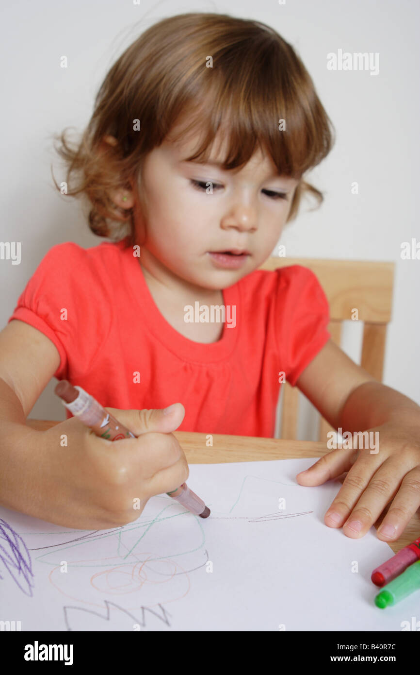 Deux ans d'un bébé fille est l'élaboration d'une holding maladroitement. crayon de couleur marron Banque D'Images