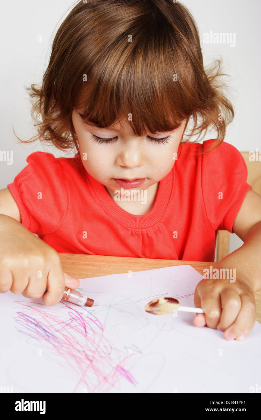 Deux Ans D Un Bebe Fille Est Maladroitement La Tenue D Un Dessin Au Crayon De Couleur Rose Photo Stock Alamy