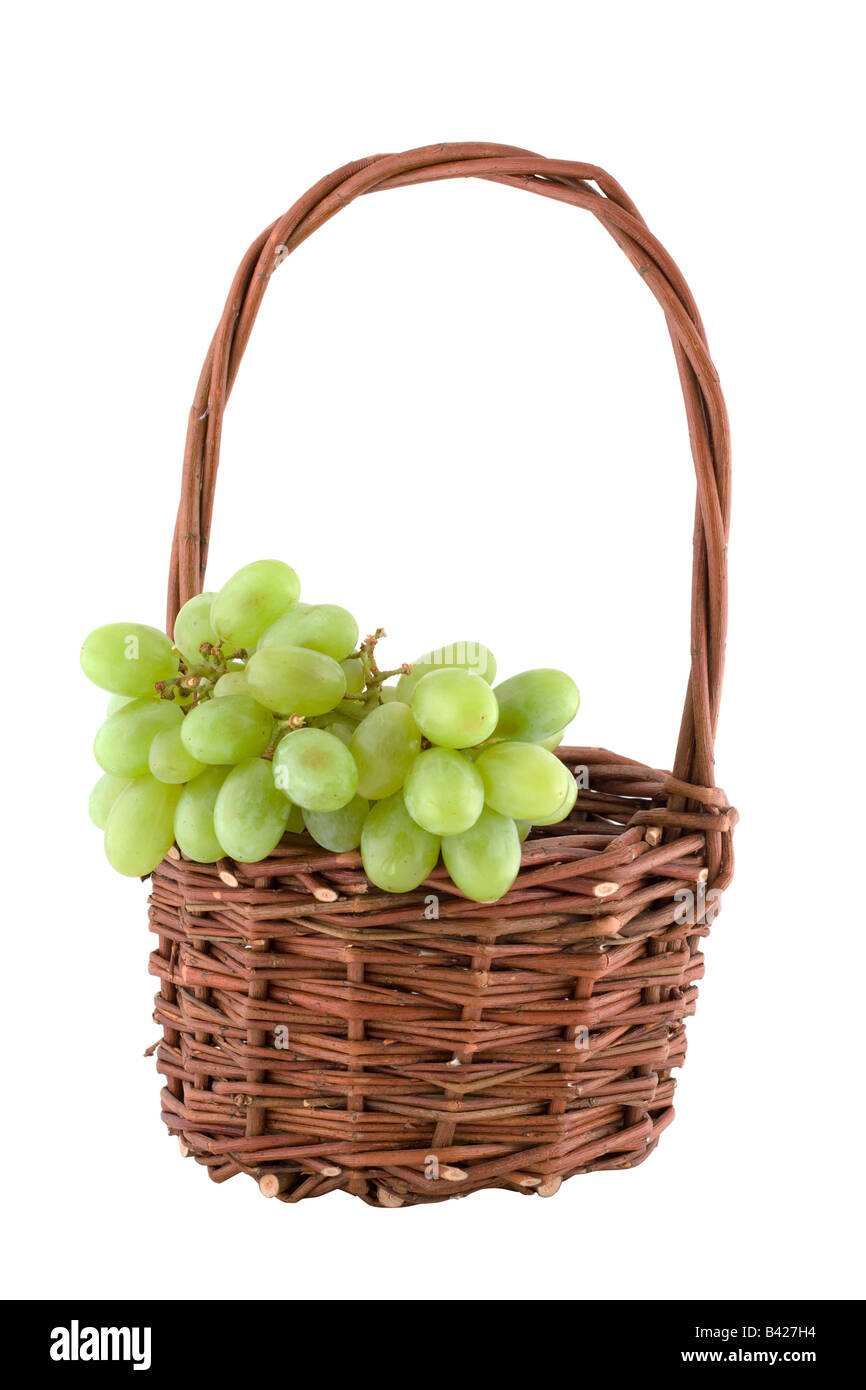 Panier en osier avec des raisins sur blanc Banque D'Images