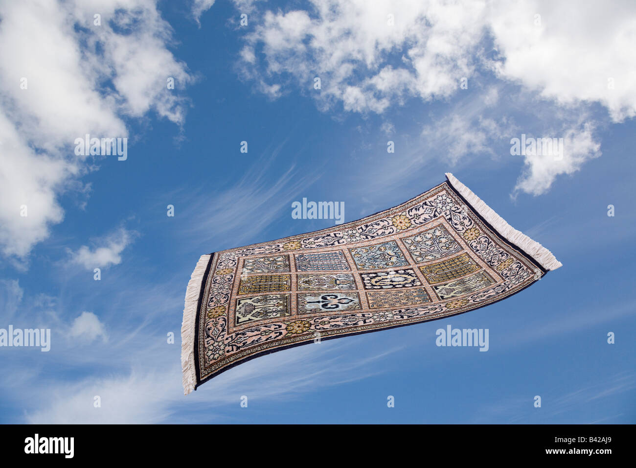 Tapis magique voler à travers le ciel bleu avec des nuages blancs Banque D'Images
