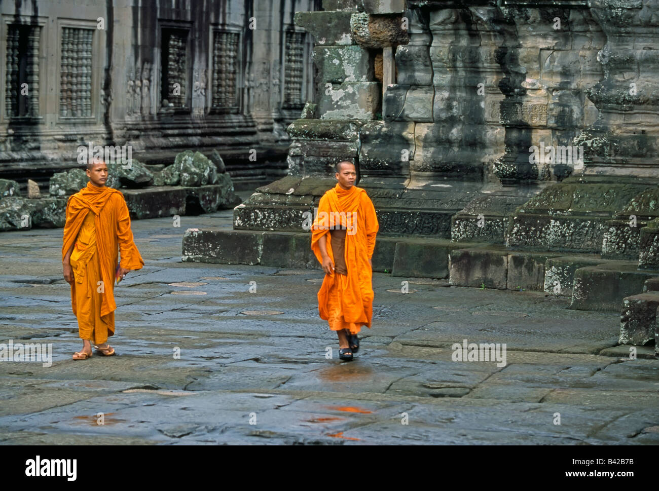 Le Cambodge, la Province de Siem Reap, Angkor Wat, moines marche à travers les ruines antiques Banque D'Images