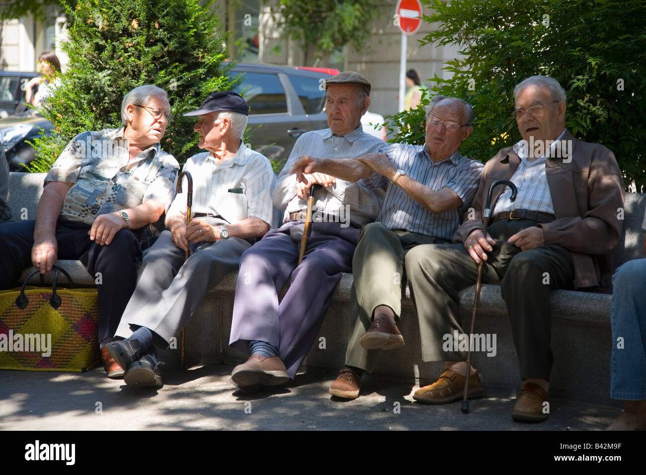 Le samedi après-midi, les hommes assis sur banc de parc en La Seu d'Urgell, (Sa Seu d'Urgell) de Catalogne, Espagne Banque D'Images