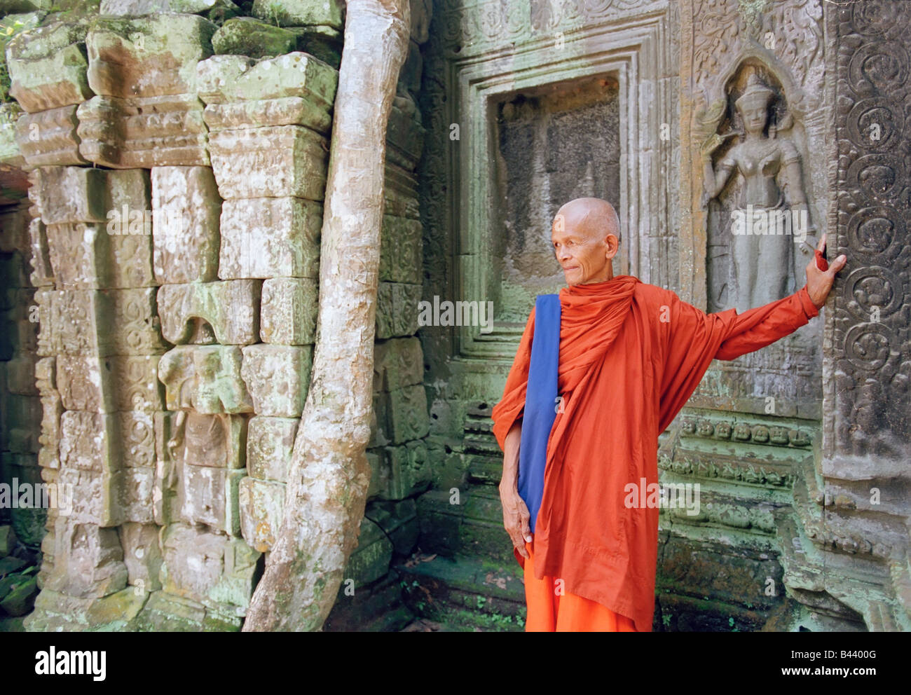 L'Asie, Cambodge, Siem Reap, Ta Prohm Temple, moine debout parmi les racines du figuier géant Banque D'Images