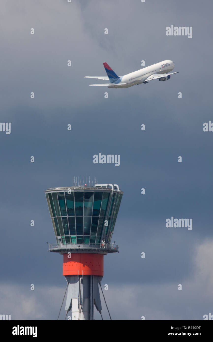 Delta Air Lines Boeing 767-332/ER décolle dans l'arrière-plan de la tour de contrôle de London Heathrow. Banque D'Images
