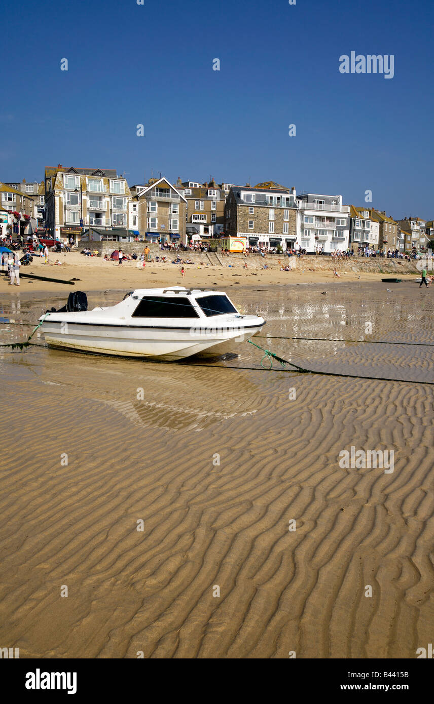 Un bateau blanc sur le port de St Ives plage à marée basse. Banque D'Images