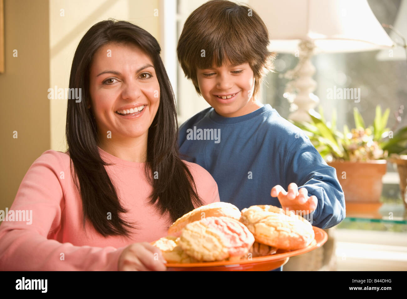 Hispanic mother and son holding plate of cookies Banque D'Images