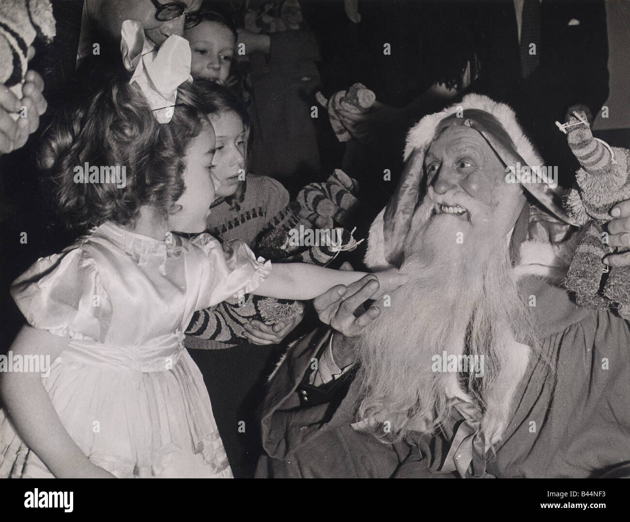 Les enfants tirant le père Noël s beard lors d'une fête donnée par le Club de la marine marchande dans la région de Rupert Street Londres Banque D'Images