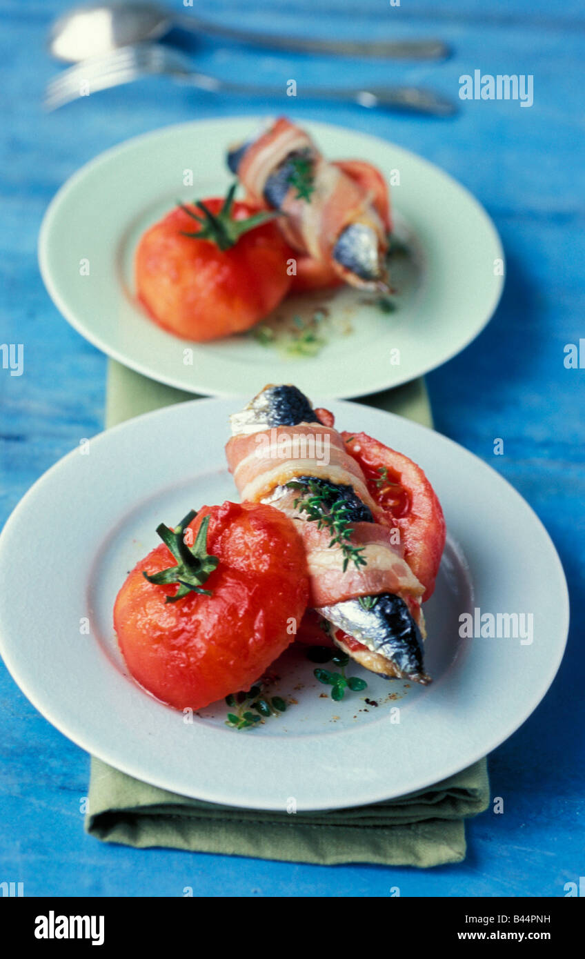 Sardines enrobé de bacon avec tomates conservées Banque D'Images