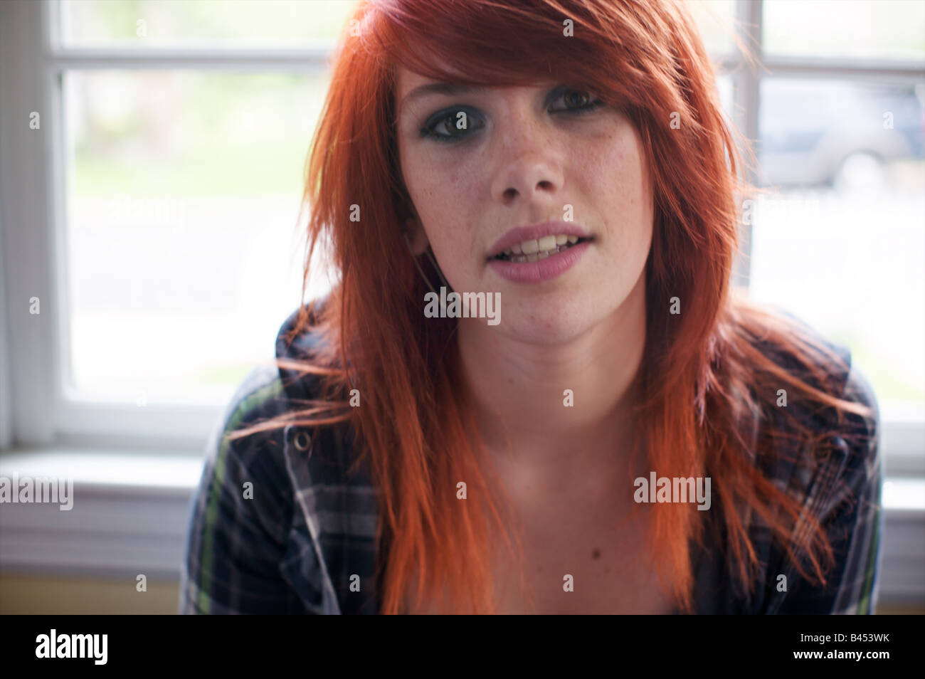 Adolescent commence à peine à sortir l'appareil photo traite franchement et se demande si ses cheveux orange choquant va obtenir son expulsion. Banque D'Images