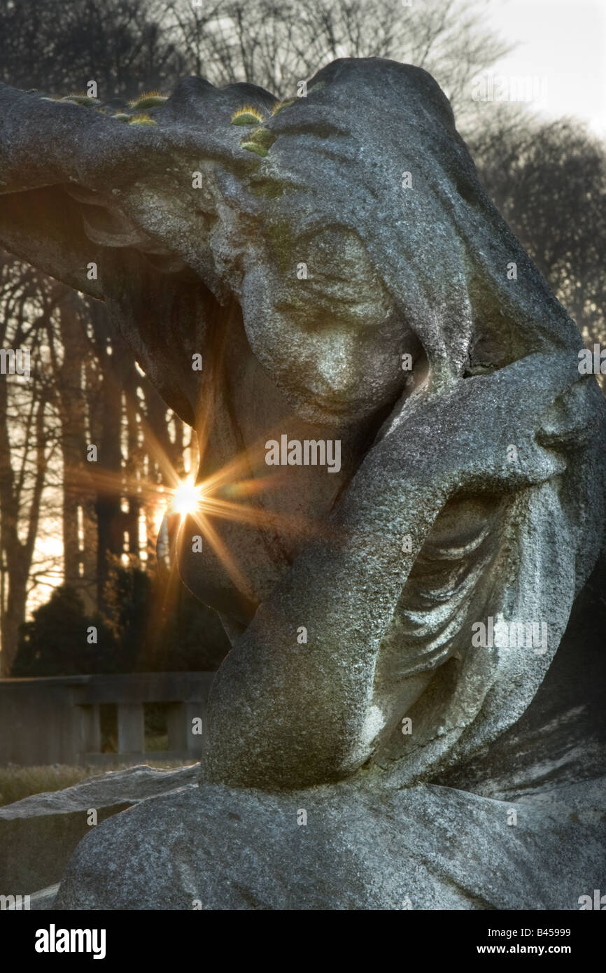 Lever du soleil à une ancienne pierre tombale avec une femme en deuil le granit Banque D'Images