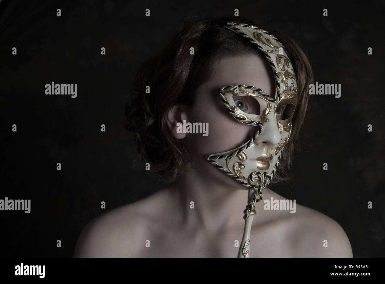 Jeune fille à la peau d'ivoire avec masque de Venise Banque D'Images