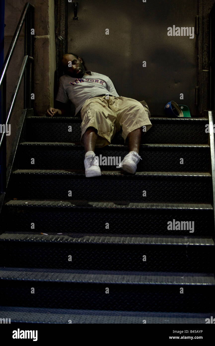 Homme de glisser sur les escaliers par la porte arrière de l'un des magasins de Manhattan NEW YORK NY USA Banque D'Images