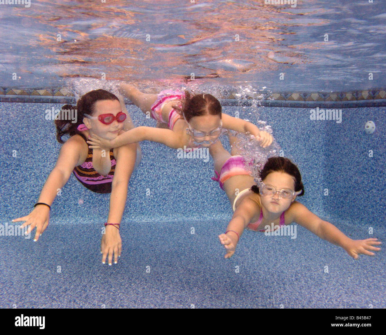 Trois filles nager sous l'eau dans une piscine Banque D'Images