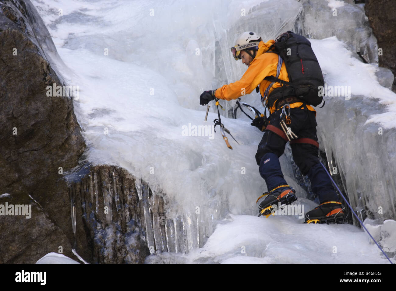 Grimpeur sur glace fixant une broche à glace sur un emplacement dans le langtang Himalaya, Népal Banque D'Images