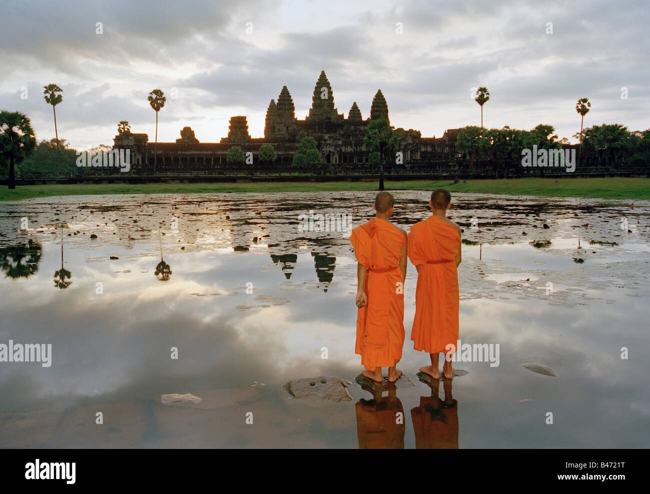 Moines debout devant le lac et la réflexion d'Angkor Wat Angkor Cambodge Banque D'Images
