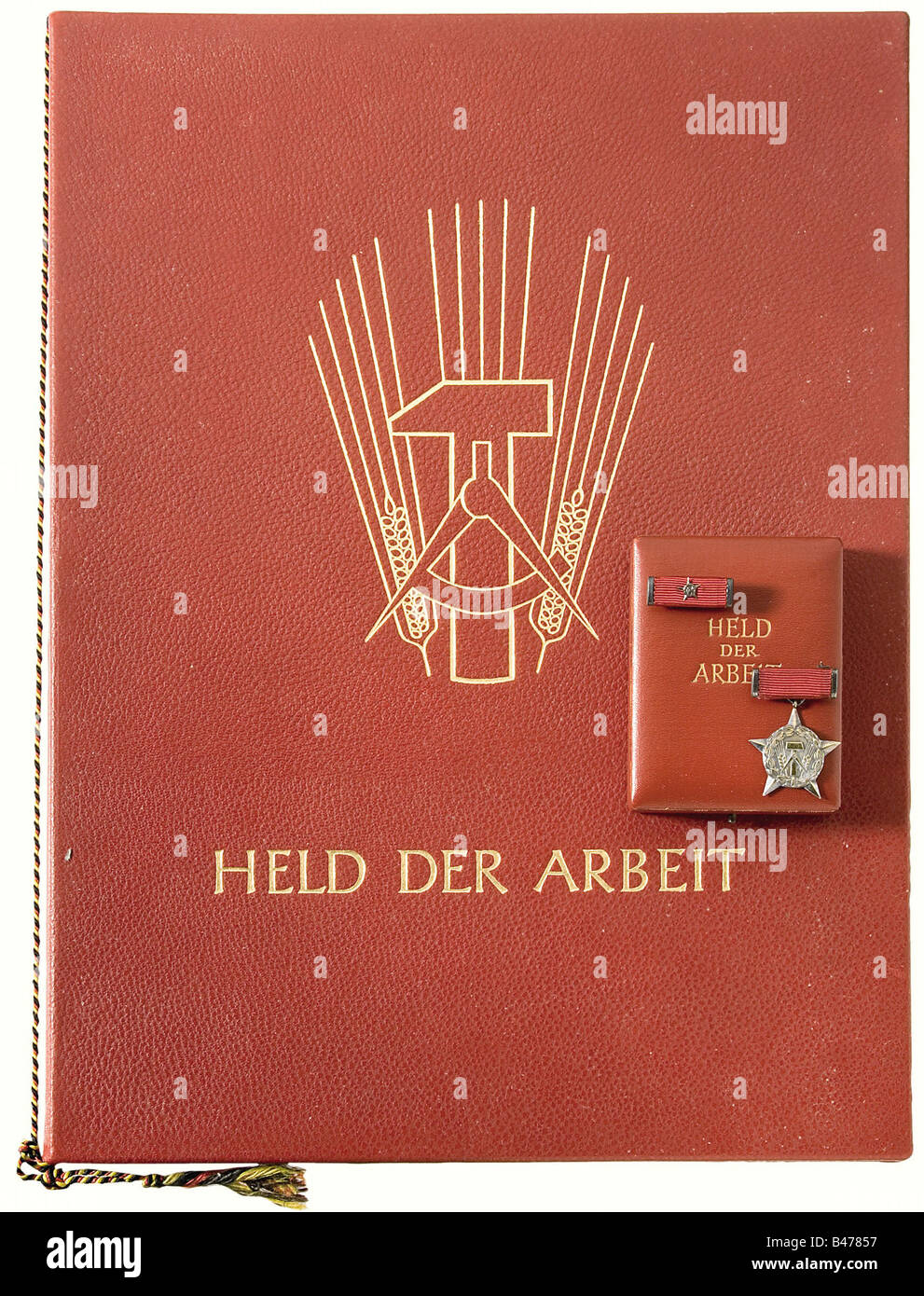 Le héros du Labour, une étoile argentée, estampillée du numéro de récompense '04/1951' et de la marque '900' à l'envers. Il y a aussi un fermoir provisoire dans un étui en cuir rouge, doré. Document de présentation avec la signature originale de Wilhelm Pieck et un sceau de cire dans un dossier en cuir estampé d'or. Aussi télégrammes de félicitations. Historique, historique, années 1950, XXe siècle, prix, prix, Allemagne de l'est, Allemagne de l'est, Allemagne de l'est, Allemagne de l'est, allemand, objet, objets, photos, médaille, décoration, médailles, décorations, coupures, découpe, coupures, coupures, , Banque D'Images