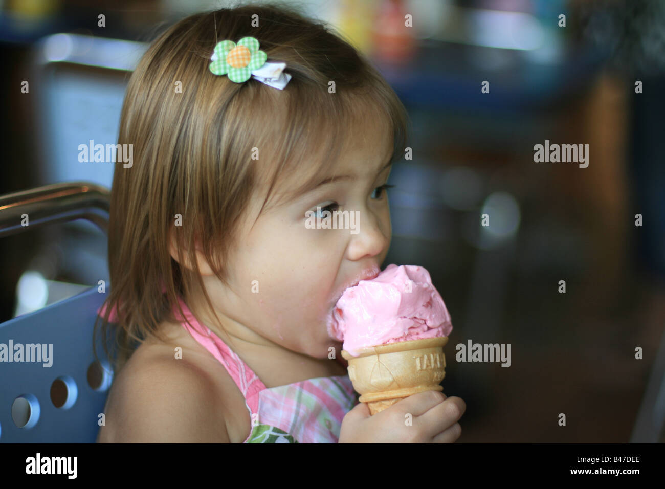 A 23 Mois Bebe Fille Prend Une Bouchee De Son Cornet De Creme Glacee Aux Fraises Photo Stock Alamy