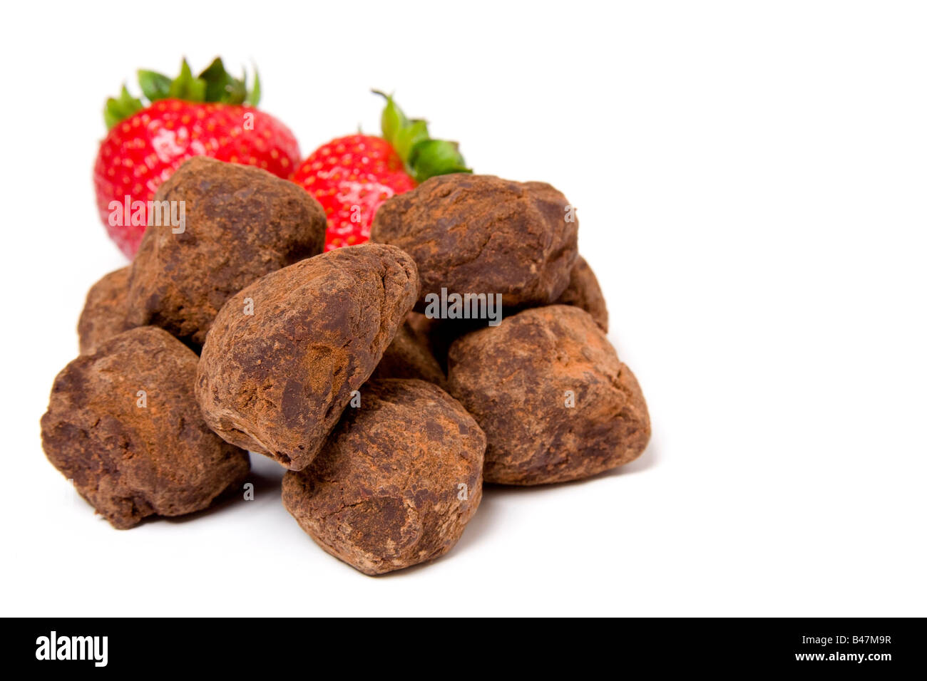 Des fraises et des truffes au chocolat sur fond blanc Banque D'Images