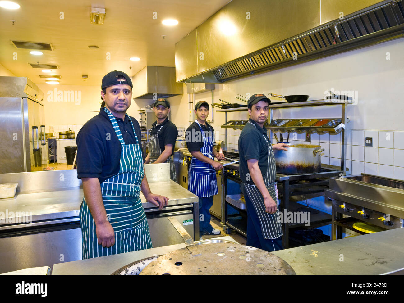 Le personnel de cuisine dans les cuisines à un restaurant indien au Royaume-Uni Banque D'Images