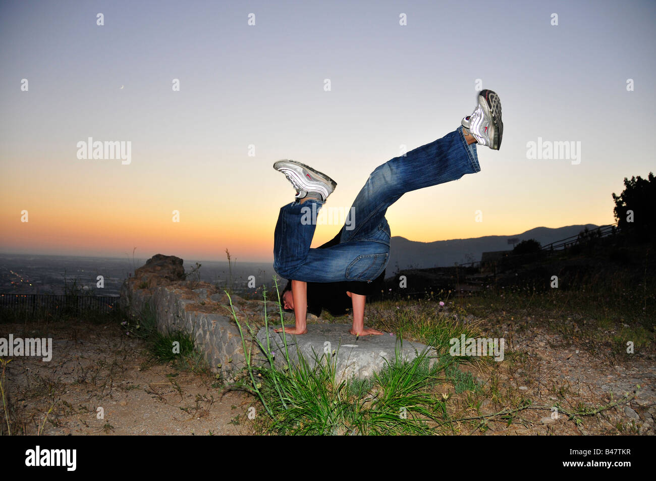 Le break dance au coucher du soleil contre la mer Banque D'Images