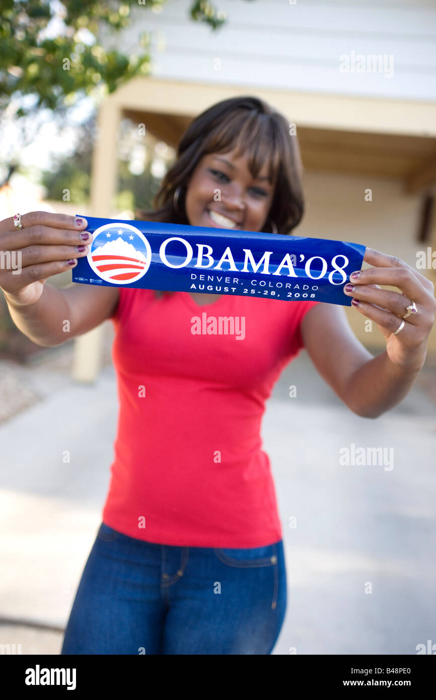 African American teenager holding campagne présidentielle de Barack Obama autocollant et smiling Banque D'Images