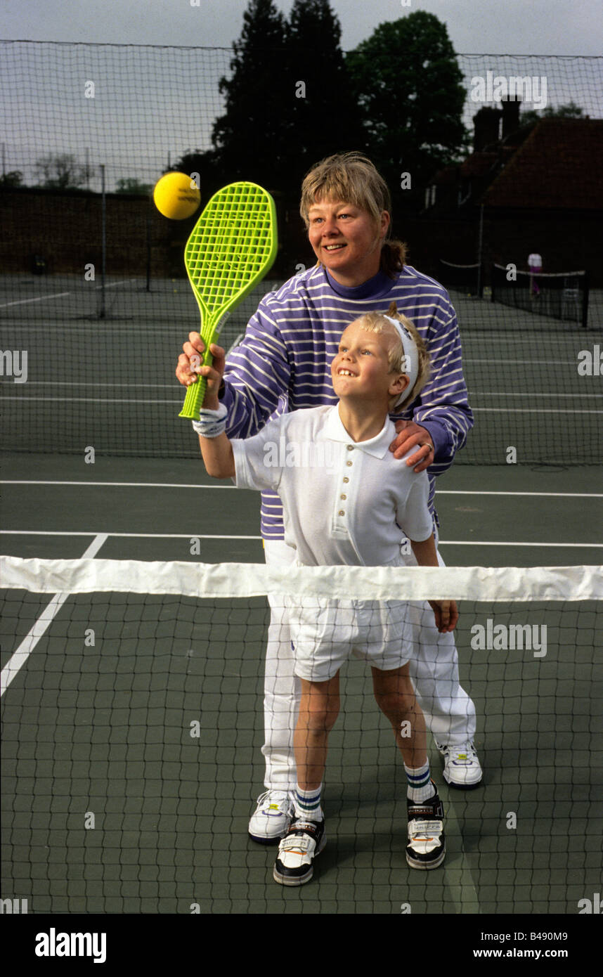Un jeune garçon d'apprendre à jouer "court tennis" Banque D'Images