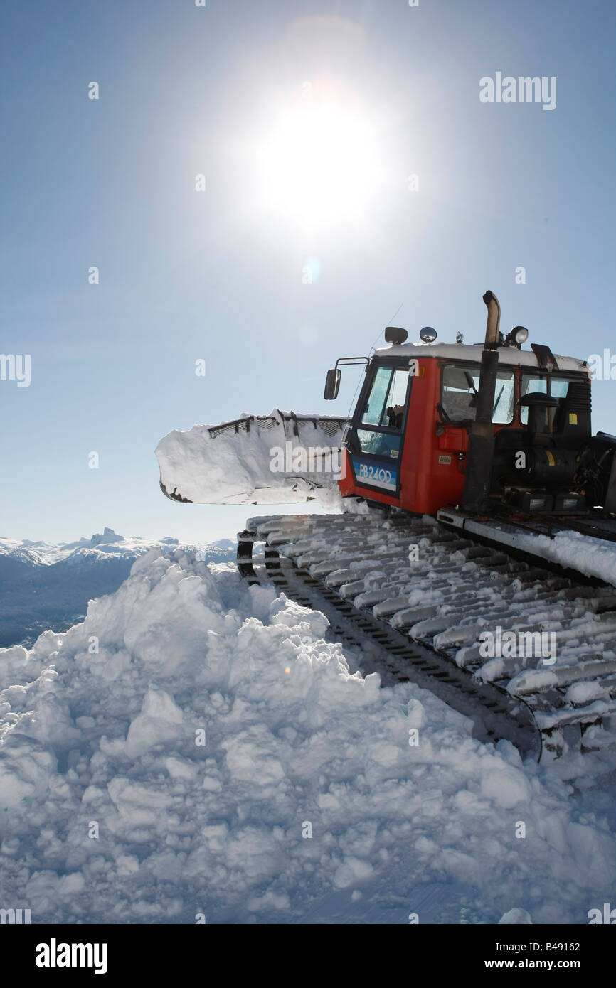 Snow cat labourant la neige pour construire un snowboard jump Banque D'Images