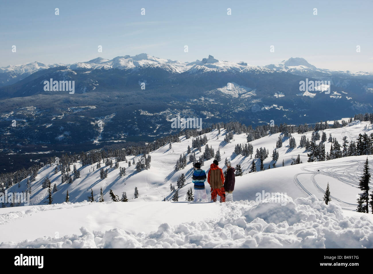 Les snowboarders avec une vue panoramique sur la montagne de Whistler et de Black Tusk Banque D'Images