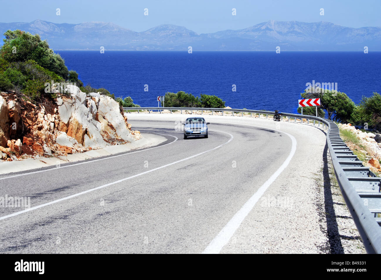 Voiture seul sur une route ensoleillée en mer littoral Banque D'Images