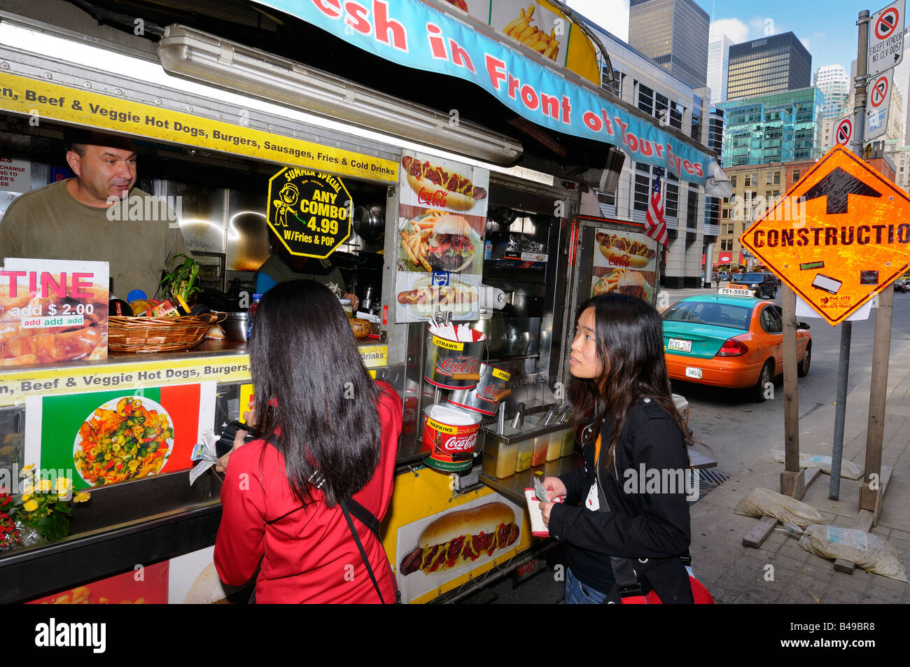 Deux touristes japonais de commander de la nourriture à un wagon de puce sur la rue Front, à Toronto au Canada Banque D'Images