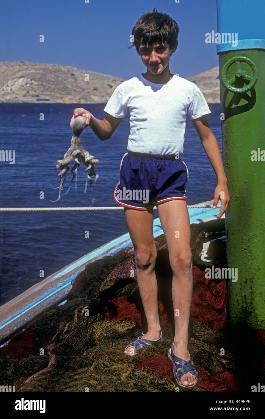 1, l'un Grec, garçon, jeune garçon, pêcheur, holding octopus. ville portuaire, ville de Ormos, Elati, iisland de Ios, Ios, Cyclades Island Group, Grèce, Europe Banque D'Images