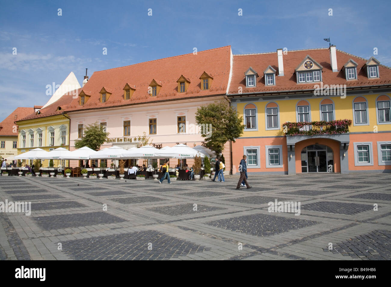 La Transylvanie Sibiu Roumanie Europe Septembre gens assis à table en face de l'hôtel dans la circulation de Piata Mare Banque D'Images