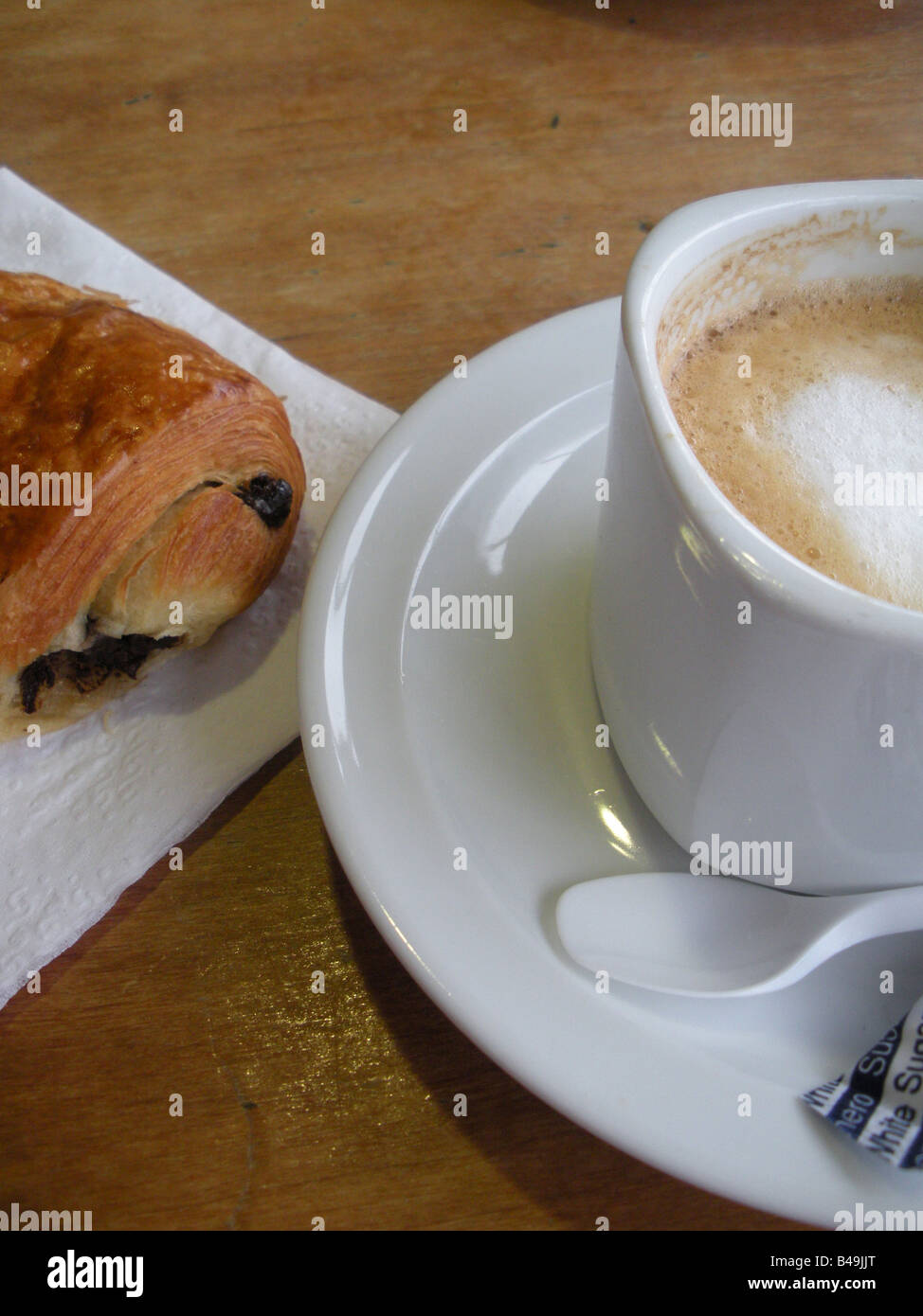 Un pain au chocolat et pâtisserie une tasse de cappuccino : une boisson à base de café préparé avec une machine à espresso, de lait chaud, mousse de lait -et étuvé Banque D'Images