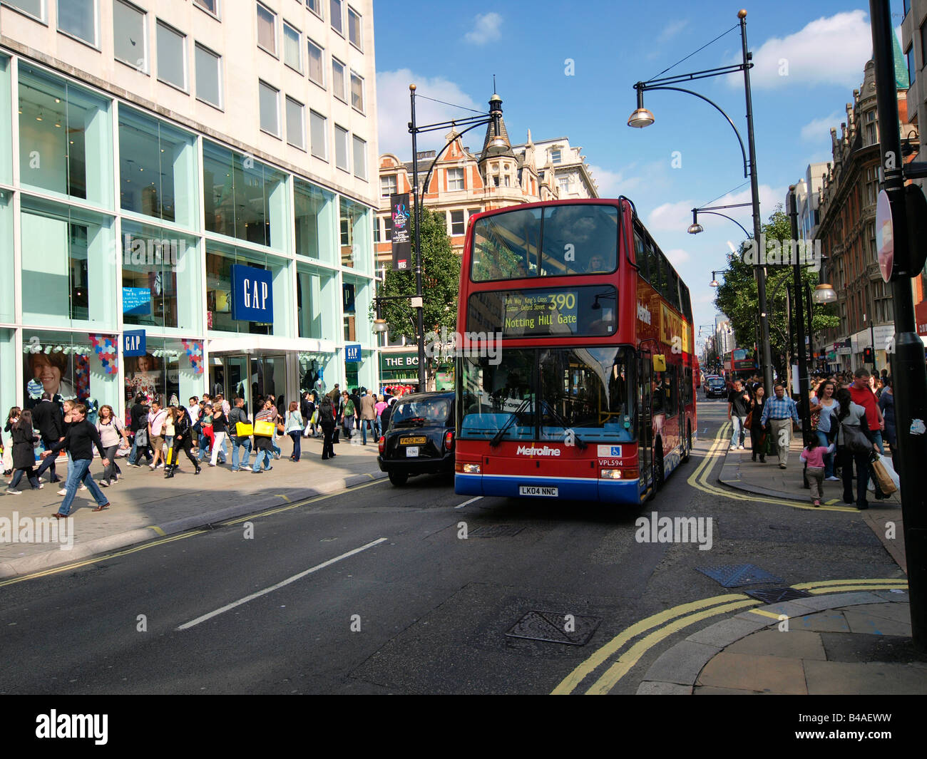 Oxford street avec ses nombreux commerces et bus rouge London UK Banque D'Images