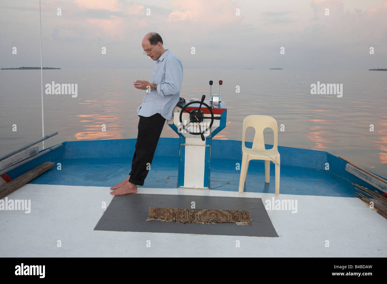 Écrivain, essayiste et philosophe Alain de Botton s'appuie contre la roue d'une traditionnelle dhoni bateau dans l'Océan Indien Banque D'Images