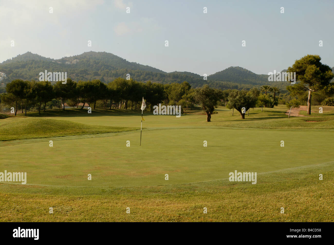 Un parcours de golf avec paysage montagnes derrière et la lumière du soleil du matin Banque D'Images