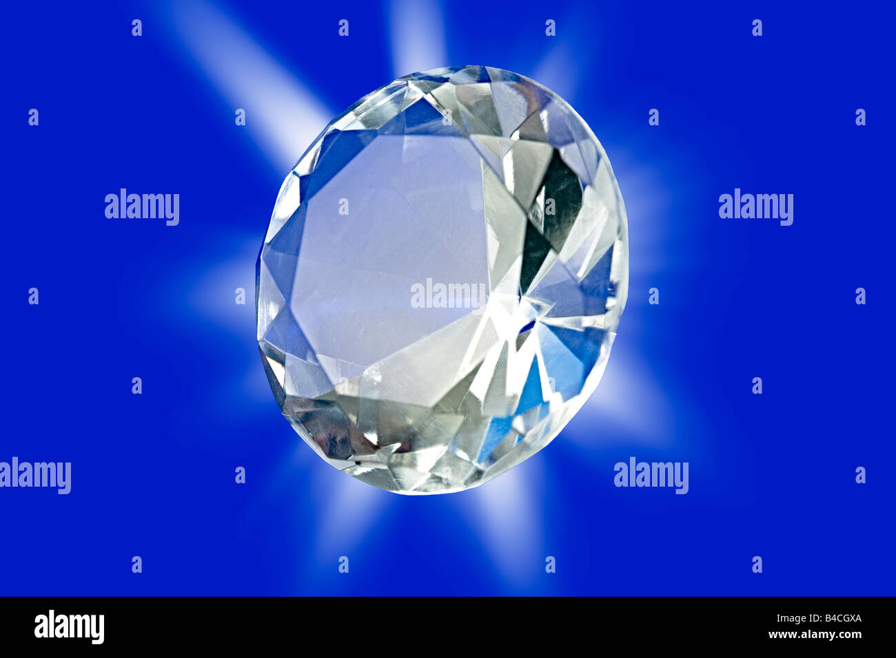 Une photo d'un diamant sur un fond bleu avec un éclatement d'étoile Banque D'Images