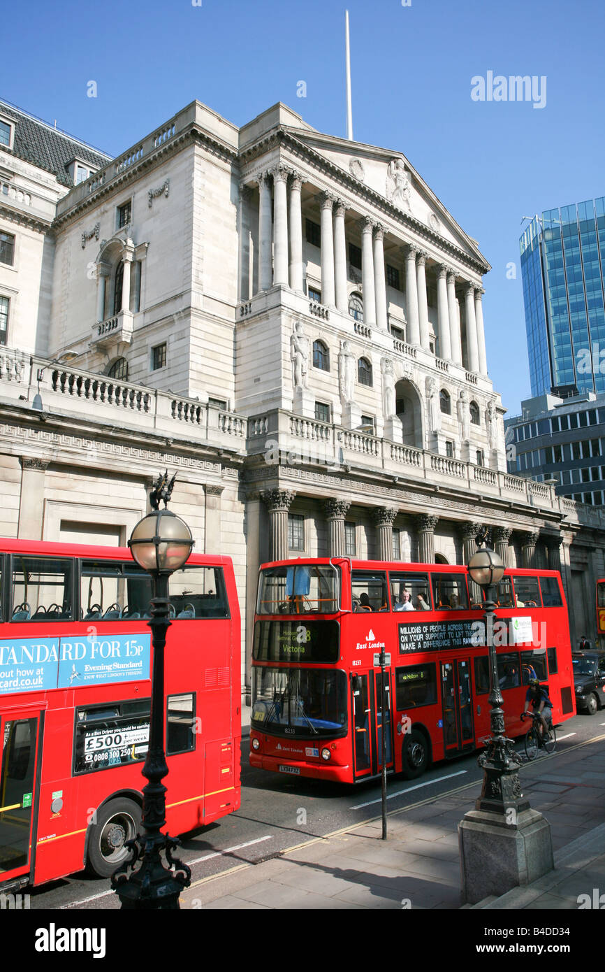 Rouge typique des bus à impériale de Londres à l'extérieur de la Banque d'Angleterre bâtiment dans la ville de London London district financier Banque D'Images